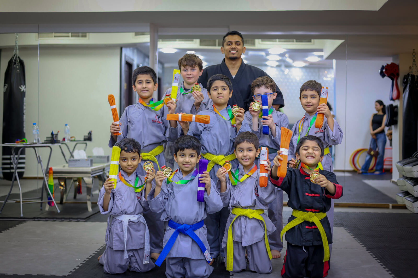 The Cage students holding their belts and medals after grading