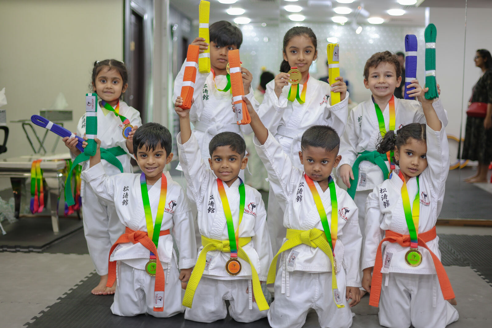 A student proudly holding a gold medal